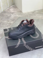 Luxury Versace dark gray sneaker with taupe faux-fur collar, lace-up design, and chunky sole.
