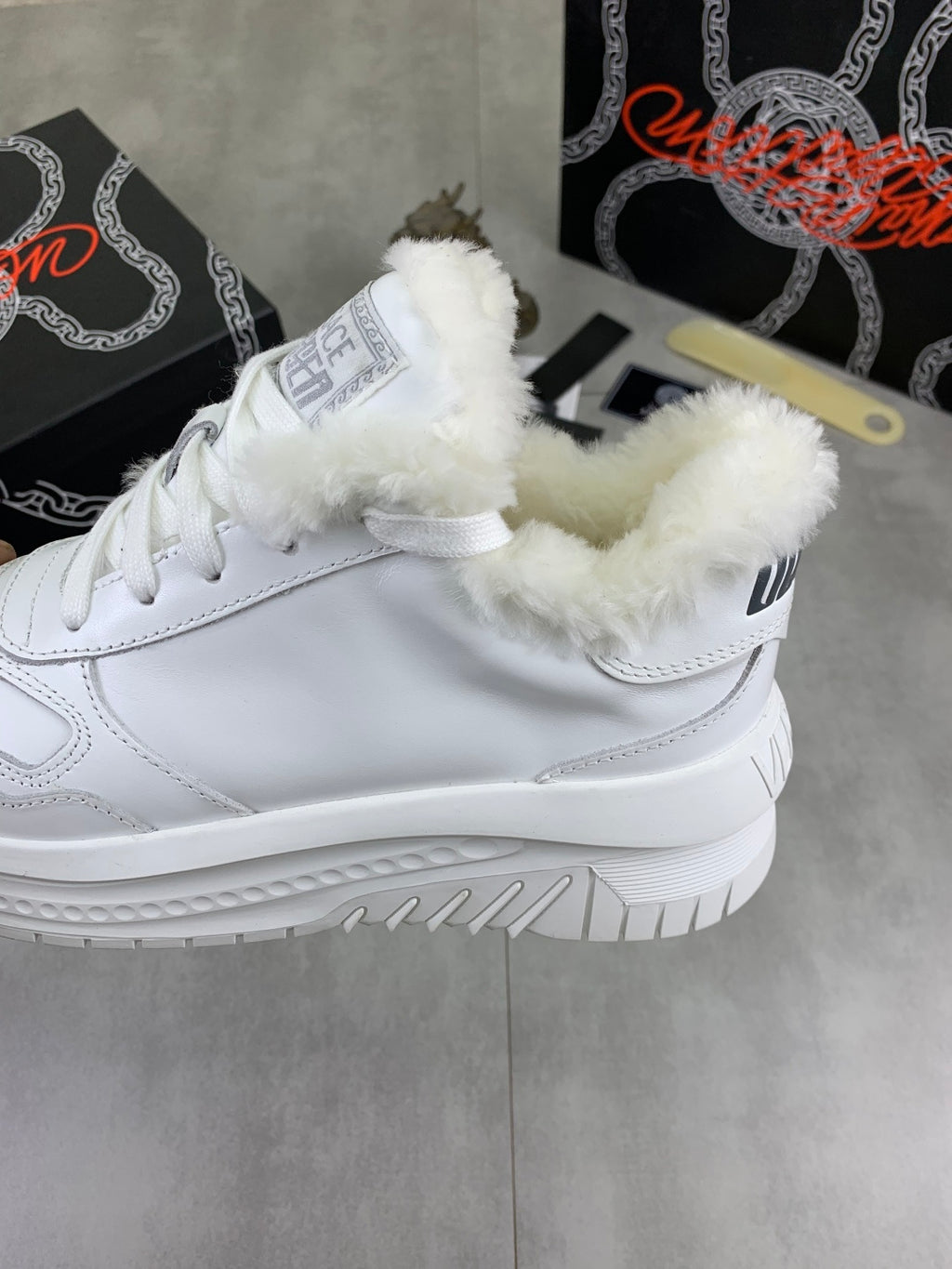 Versace white high-top sneaker with fuzzy inner lining and lace-up closure