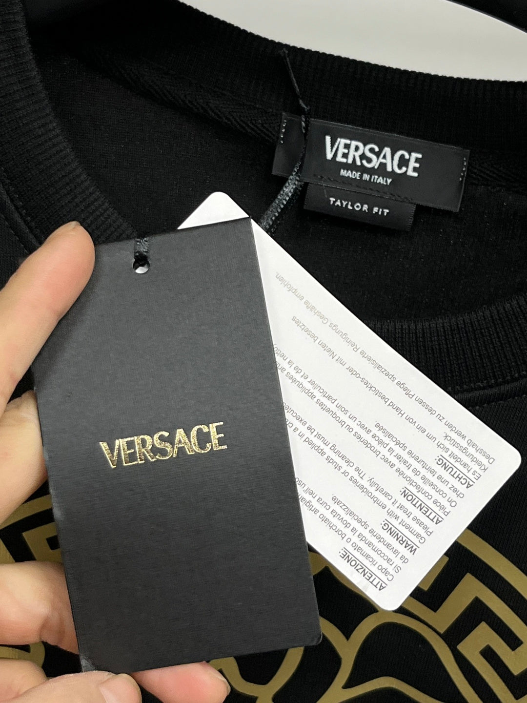 Versace crewneck sweatshirt black with clothing tag reading VERSACE and size info
