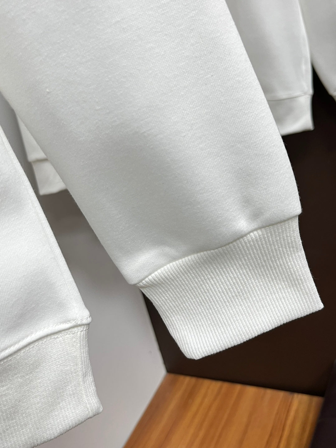 White crewneck sweatshirt sleeve with ribbed cuff detail