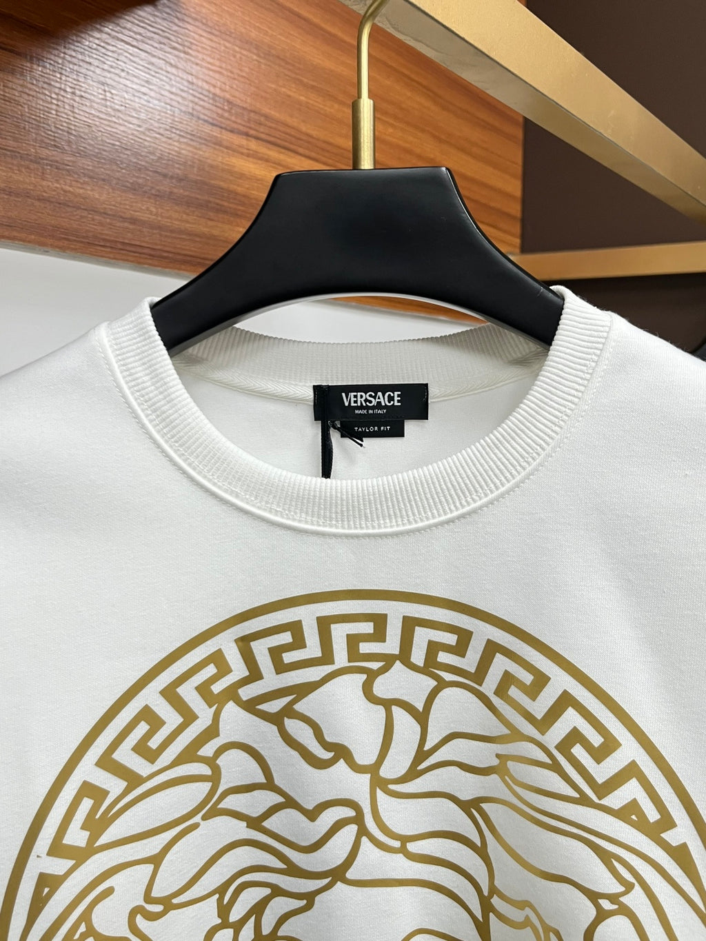 White crewneck sweatshirt with ribbed collar and gold Medusa emblem detail