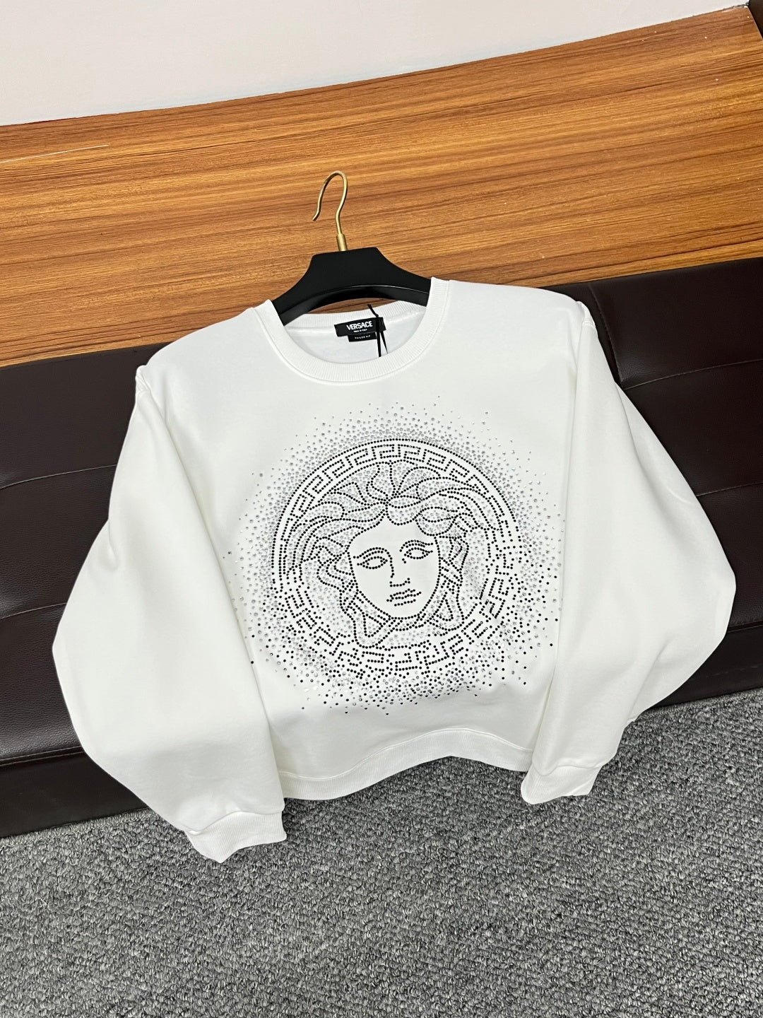 White crewneck sweatshirt with studded Medusa-style face graphic on the front