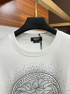 White crewneck sweatshirt with ribbed collar and studded Medusa-style chest graphic