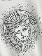 White sweatshirt featuring studded Medusa-style face print within a circular pattern