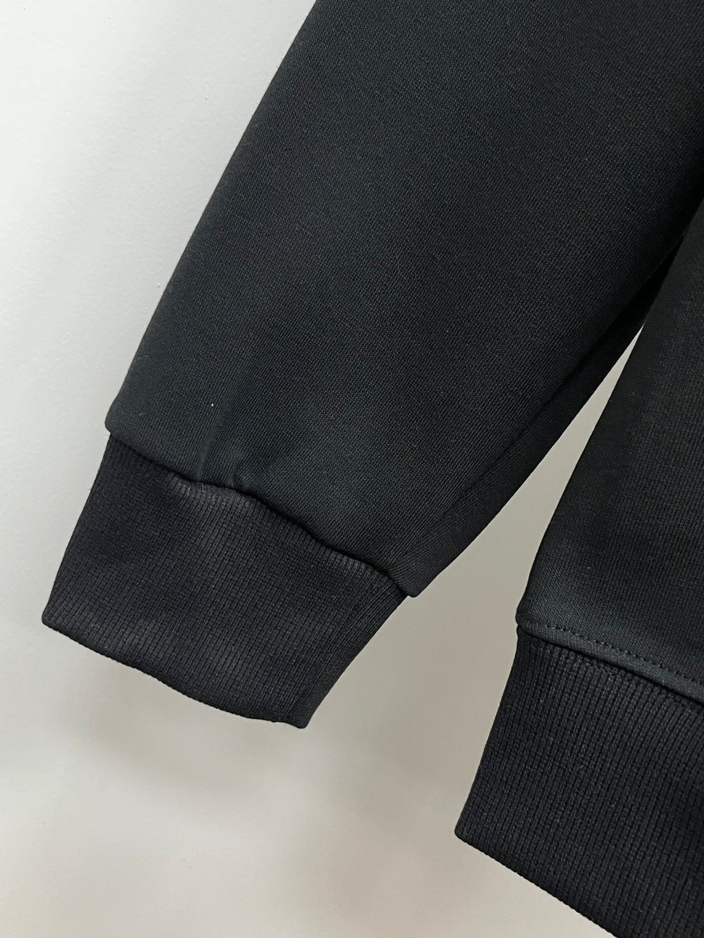 Black sweatshirt with ribbed sleeve cuff and straight hem