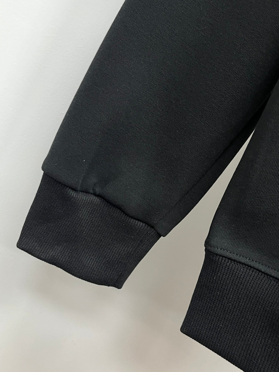 Black sweatshirt with ribbed sleeve cuff and straight hem