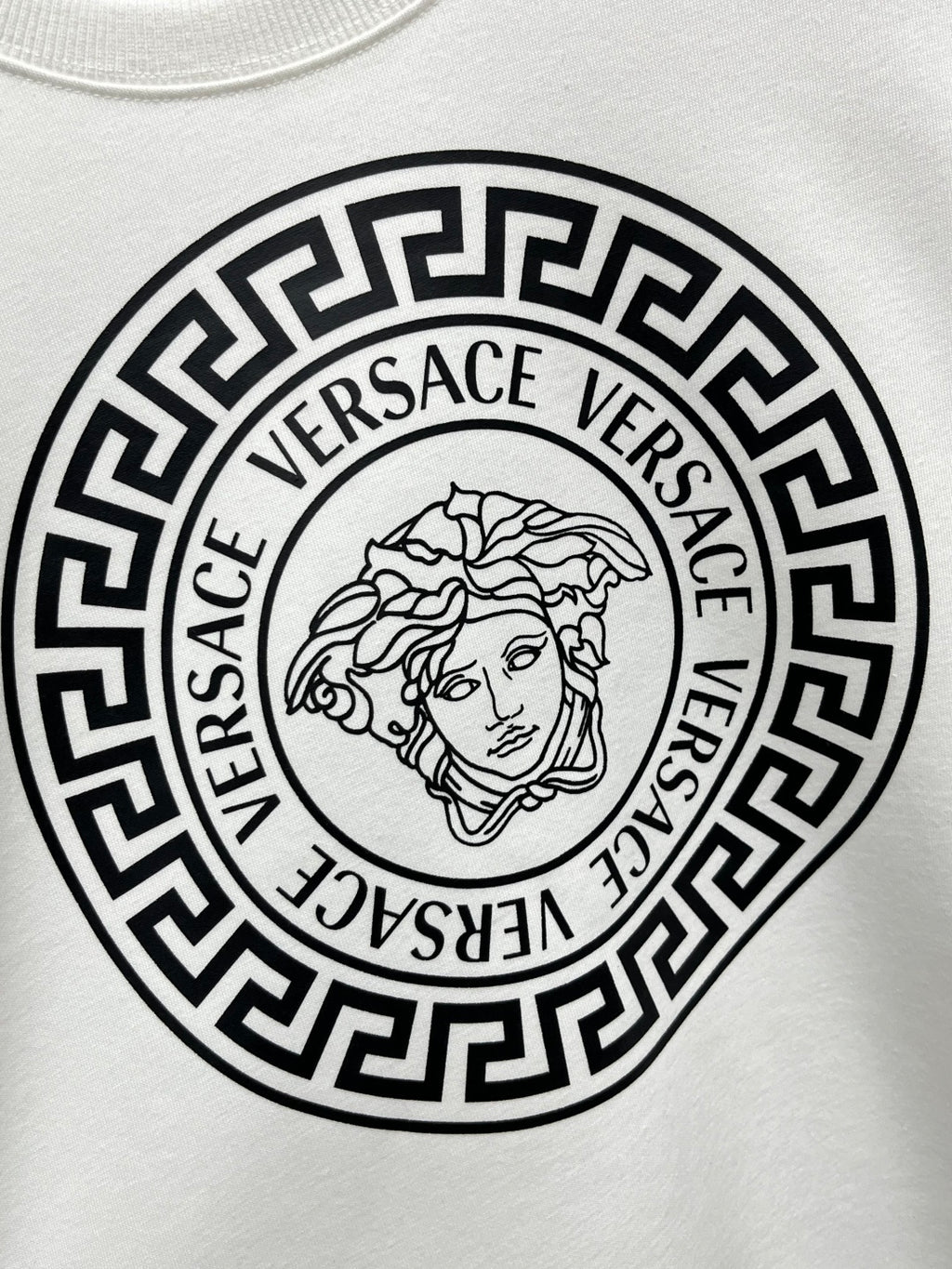 White Versace sweatshirt chest graphic featuring Medusa line art in circular border