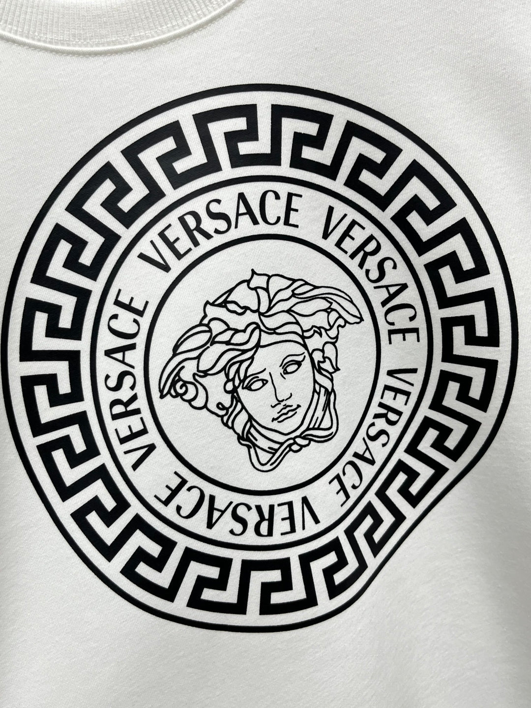 White Versace sweatshirt chest graphic featuring Medusa line art in circular border