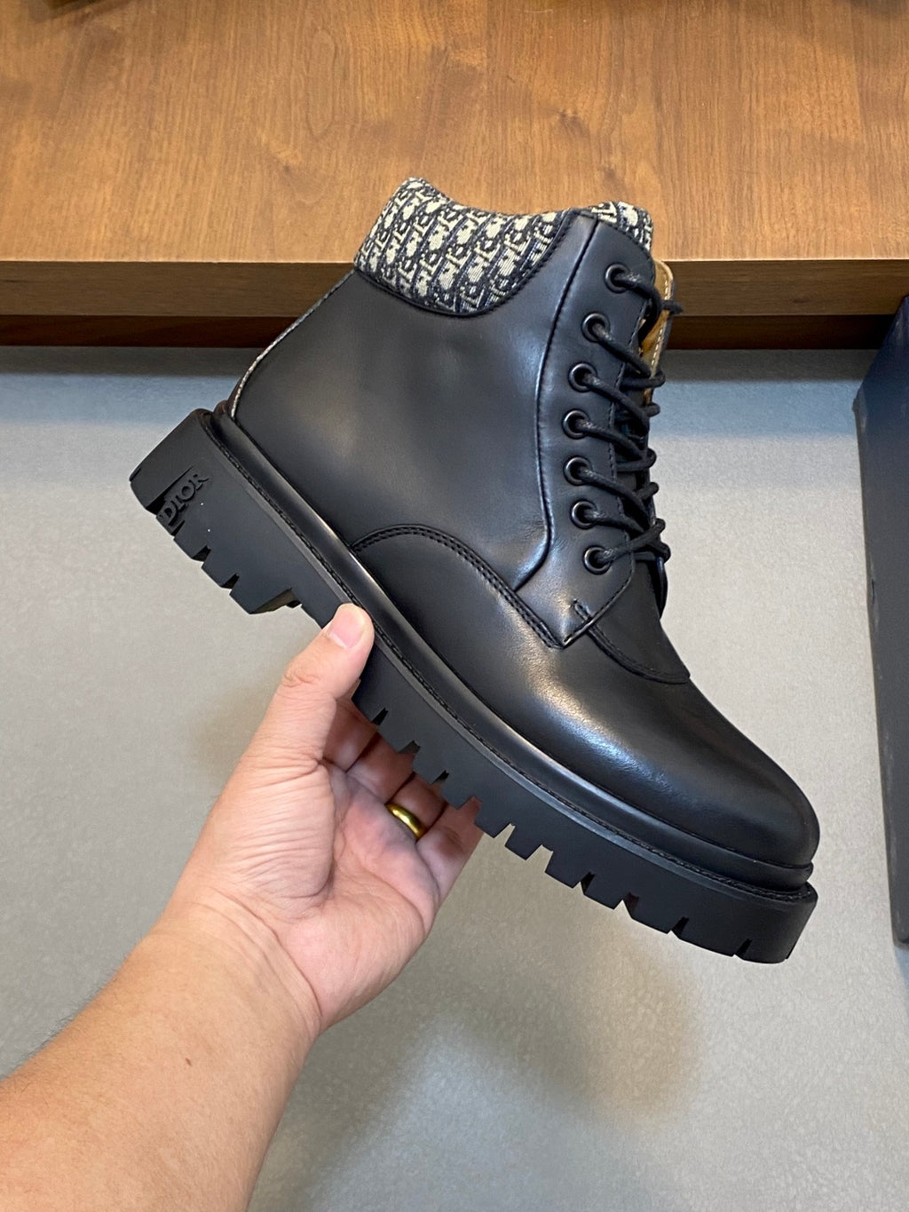 Side view of dark lace-up ankle boots with patterned collar and textured lug sole