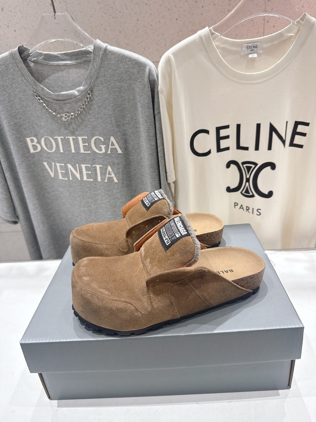 Brown suede slide sandals with shearling lining and Balenciaga label on strap