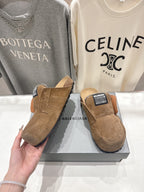 Brown suede slip-on sandals with shearling lining and angled side view