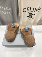 Pair of brown suede slip-on sandals with shearling lining and Balenciaga top label
