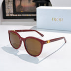 Sunglasses with red frames and amber gradient lenses, gold logo detail on temple