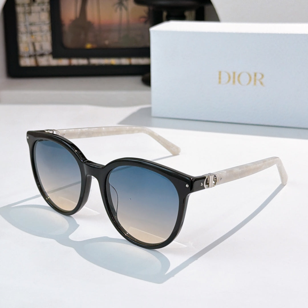 Sunglasses with black frames and blue gradient lenses, gold hinge and logo detail