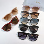 Assorted sunglasses with various frame colors and tinted lenses, stacked on display