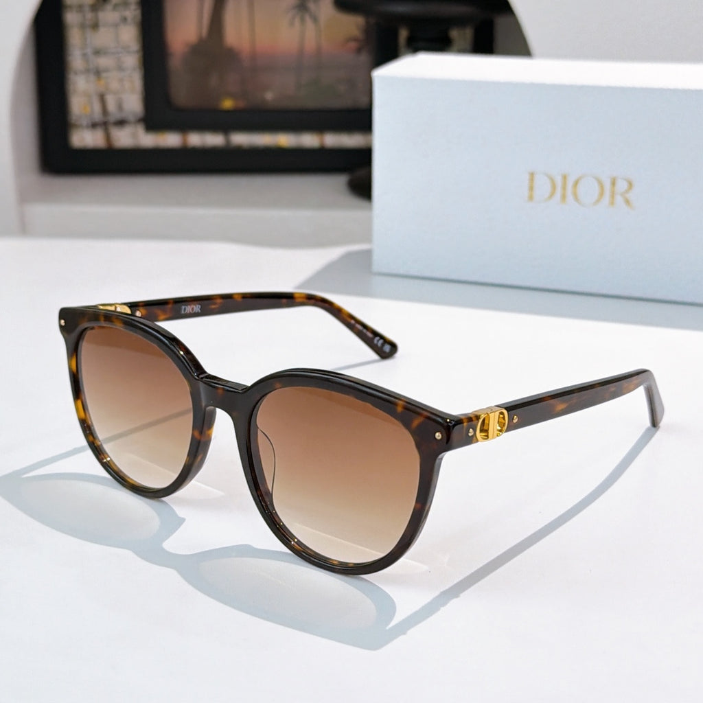 Sunglasses with dark tortoise and black frames, brown gradient lenses, gold hinge detail