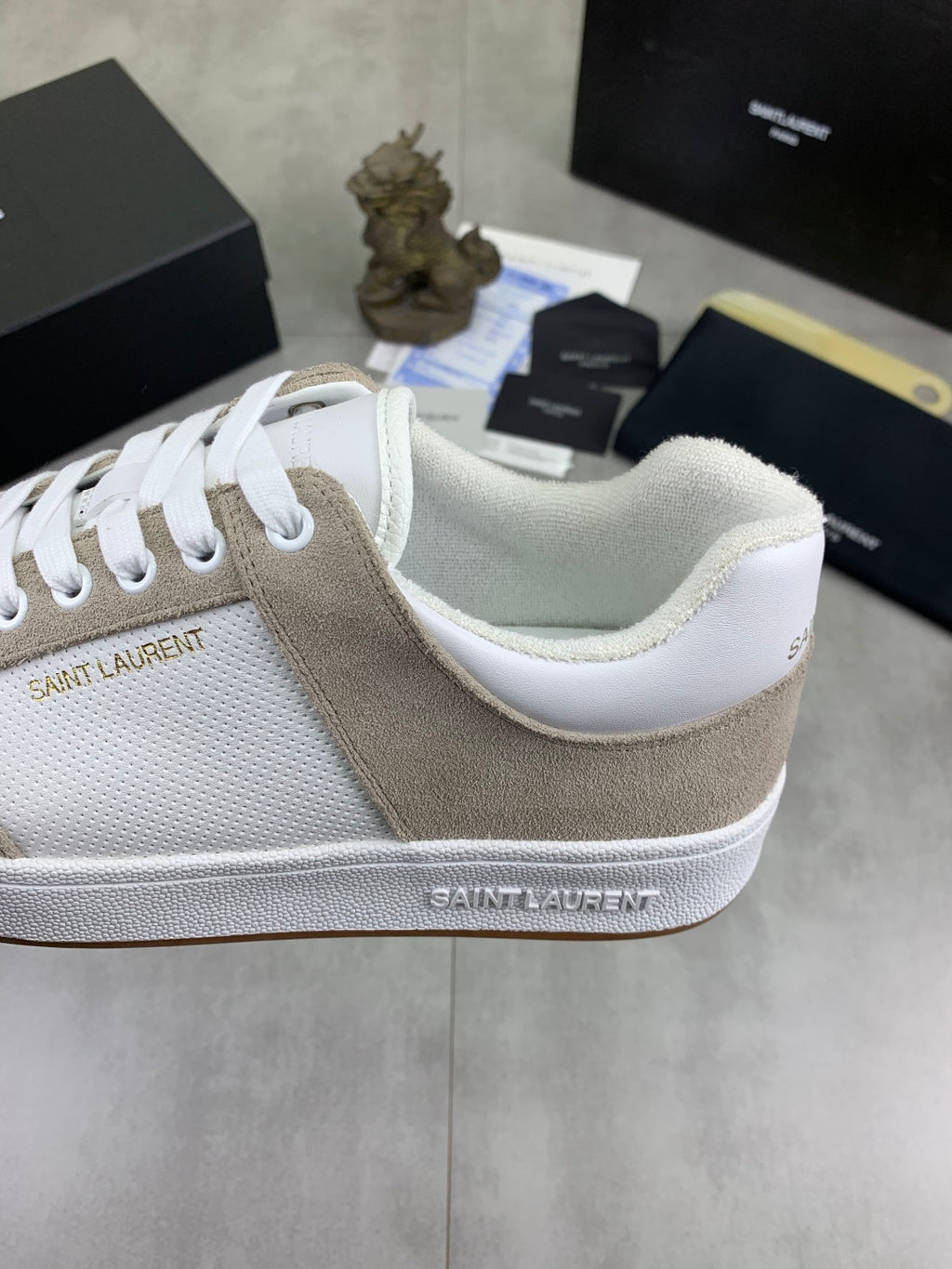 Low-top sneakers close-up, white mesh with beige suede side stripe and white sole