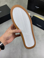 Shoe outsole view, white textured tread with tan rubber edge around the sole
