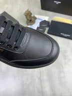 Close-up of unisex dark navy lace-up sneaker with textured stitching and eyelets