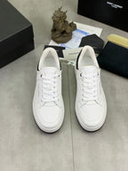 Pair of white low-top sneakers with lace-up design and textured upper