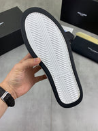 Sole of white low-top sneaker showing chevron tread and navy outer edge