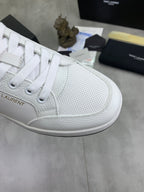 White low-top sneaker with textured toe, white laces, and logo detailing on side