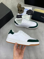White leather low-top sneakers with green suede trim and gum outsole