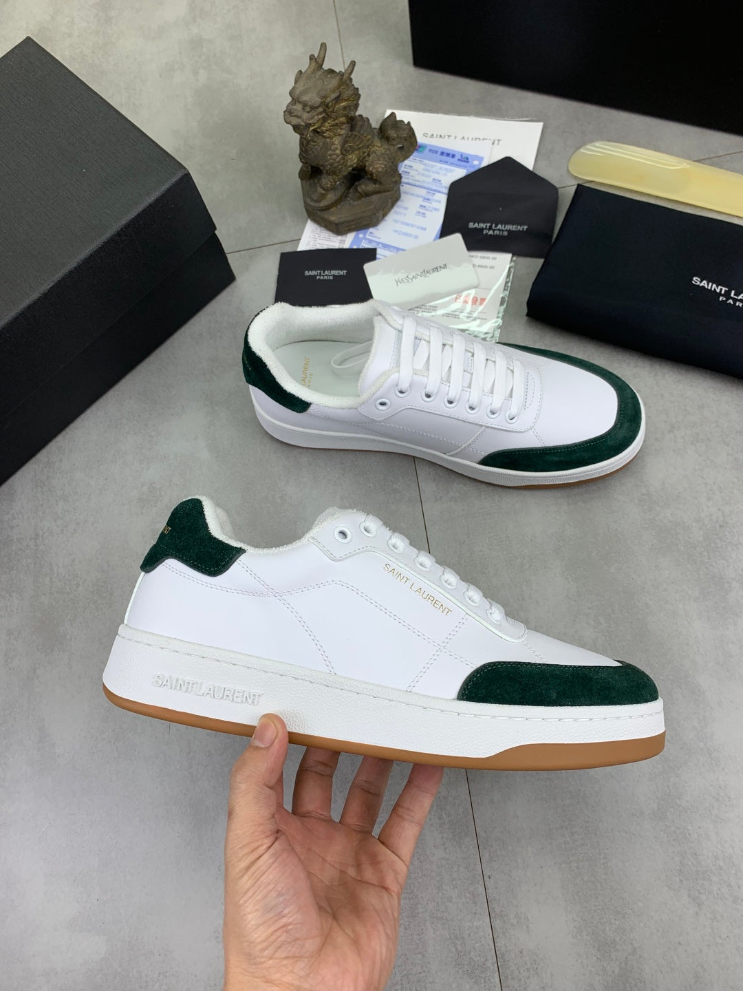 White leather low-top sneakers with green suede trim and gum outsole