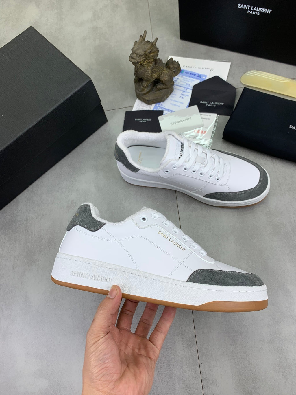 Unisex low-top sneakers: white upper, gray heel panel, gum sole.