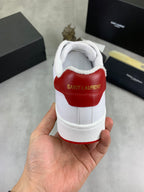 White sneaker heel view with SAINT LAURENT text on red panel and white cup sole.