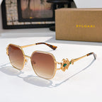 Bvlgari sunglasses with gold frame, warm brown tinted lenses, green gem temple detail
