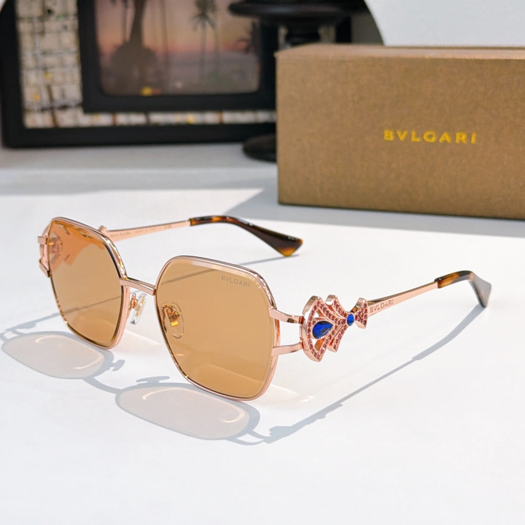 Bvlgari sunglasses with gold frame, amber tinted lenses, blue gem ornate temple