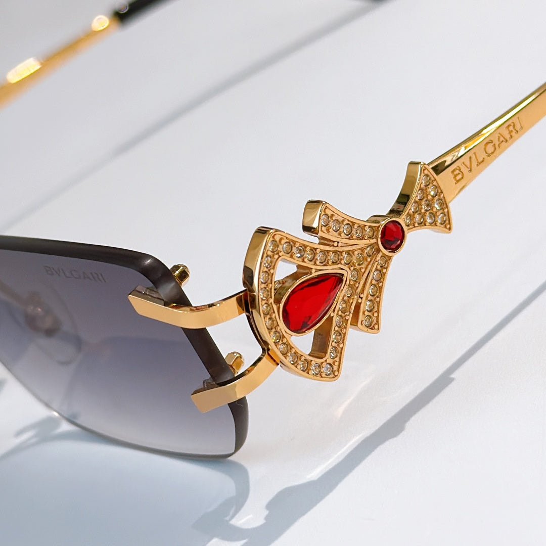 Bvlgari close-up sunglasses with gold jeweled frame and red stone temple detail