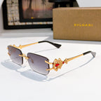 Bvlgari gold-tone sunglasses with dark gradient lenses and red gem jeweled temple detail