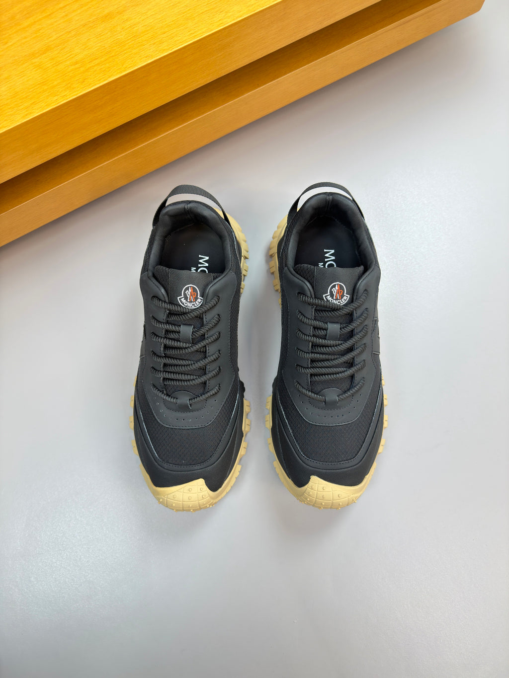 Moncler lace-up sneakers pair, dark navy uppers with textured sole in gum yellow