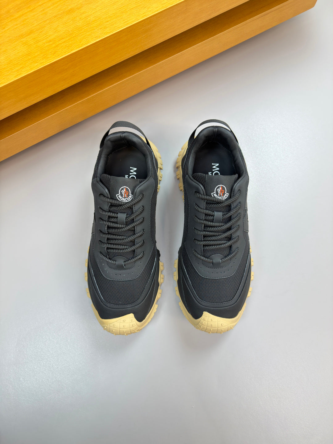 Moncler lace-up sneakers pair, dark navy uppers with textured sole in gum yellow
