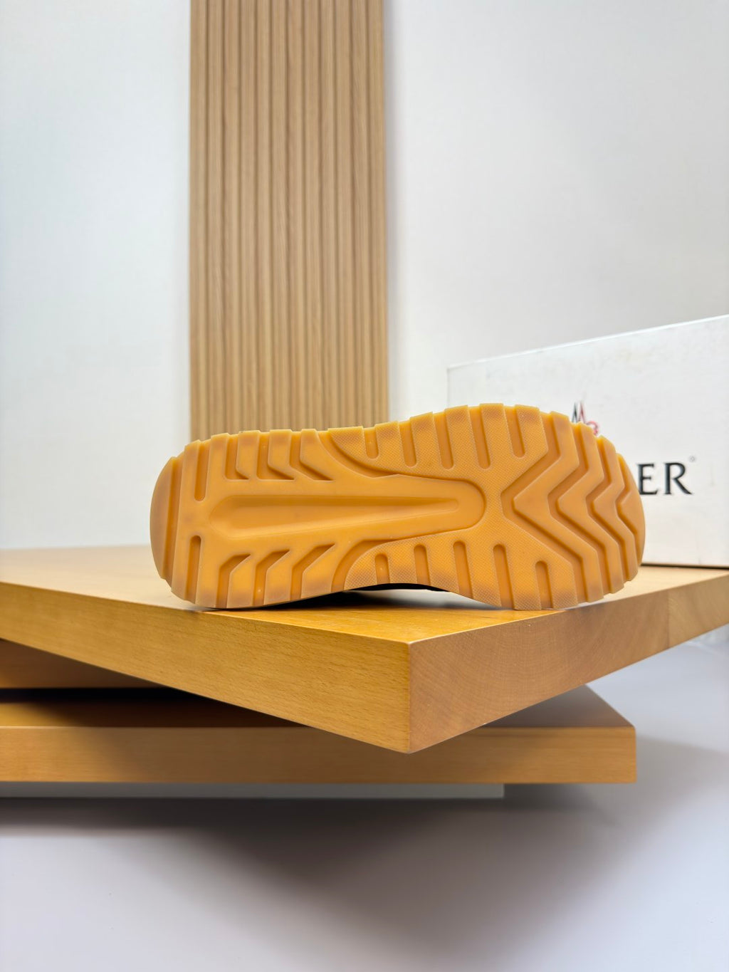 Sneaker outsole view; textured tread on light cream rubber sole.