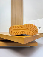 Sneaker outsole view; textured tread on light cream rubber sole.