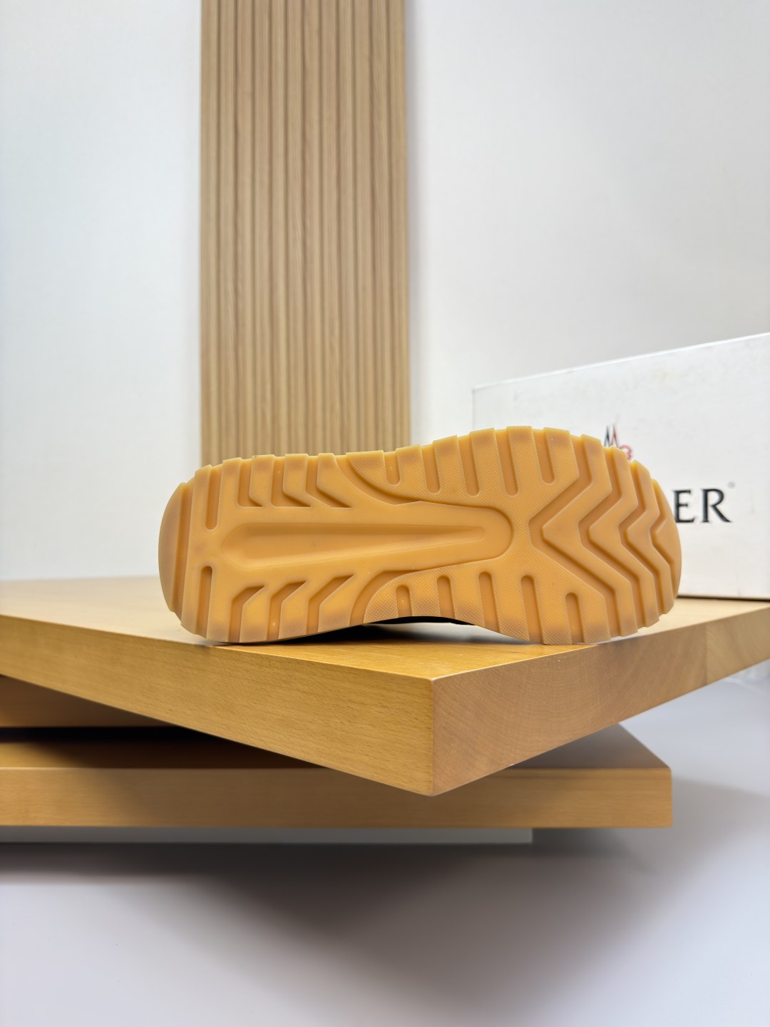 Sneaker outsole view; textured tread on light cream rubber sole.