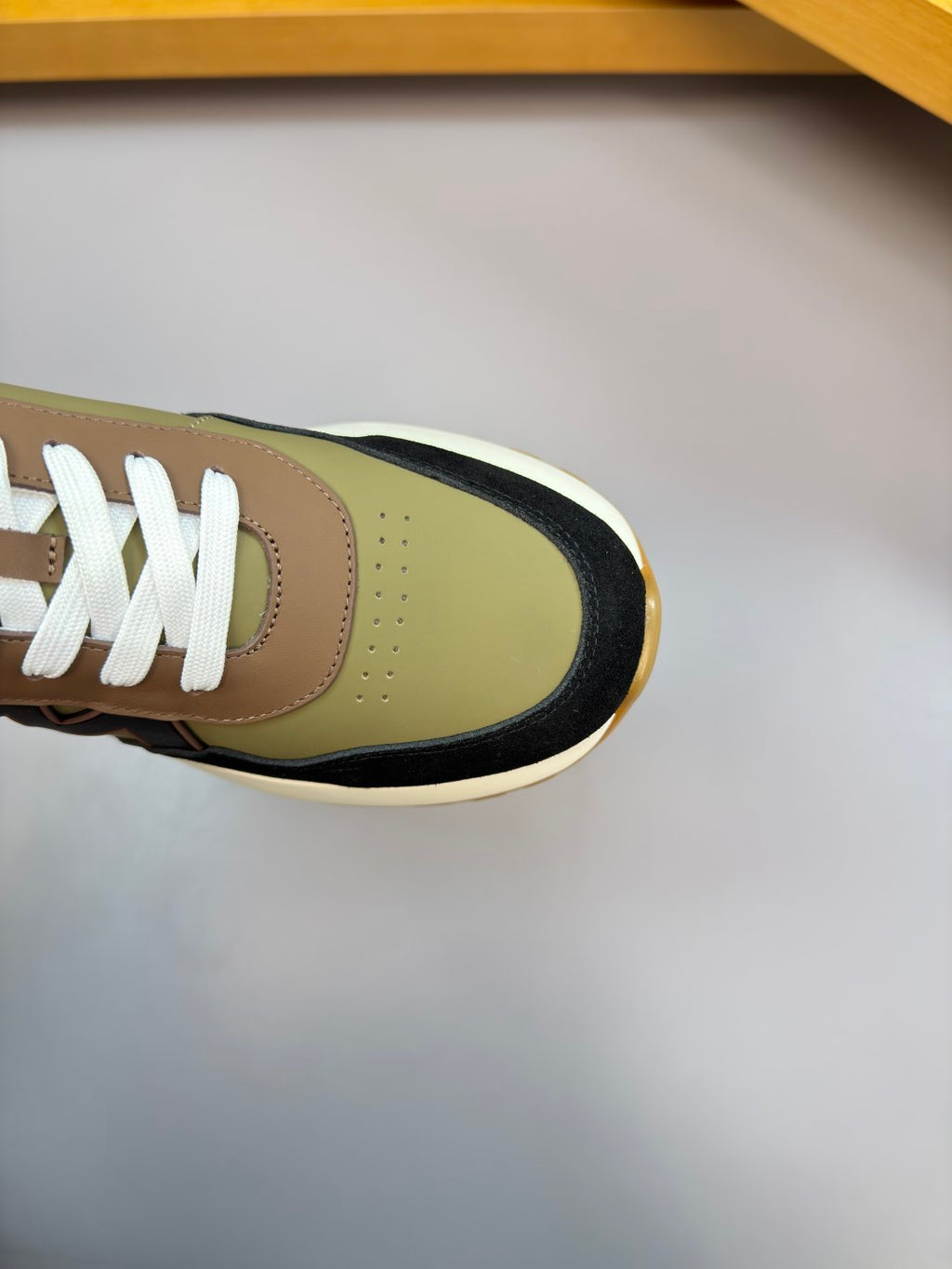 Close-up of sneaker toe and laces; olive leather with black trim and white laces.