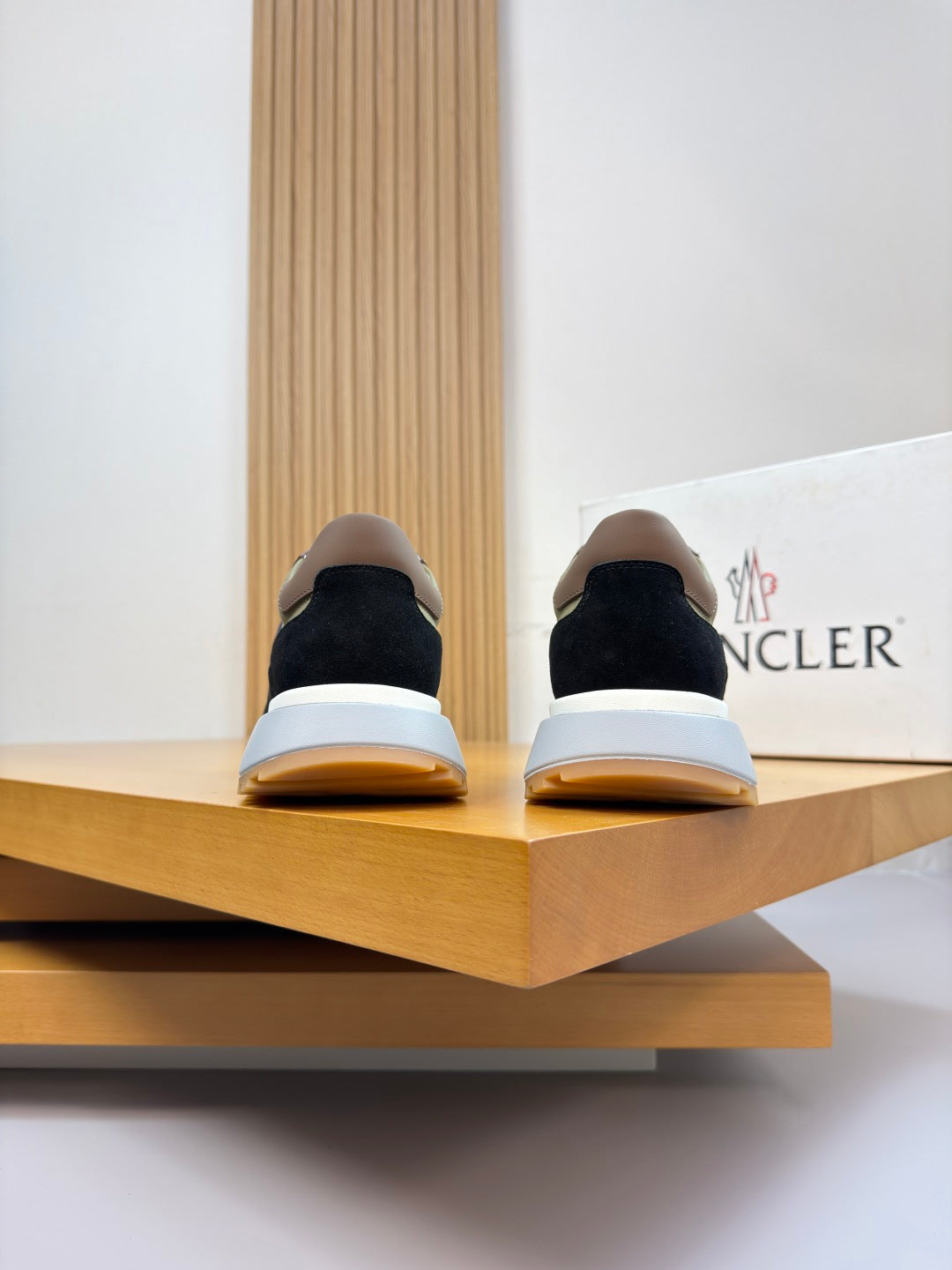 Sneakers from behind on display; dark uppers with white soles and brown heel accents.
