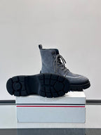 Moncler lace-up ankle boot with underside view; dark blue suede and treaded rubber sole