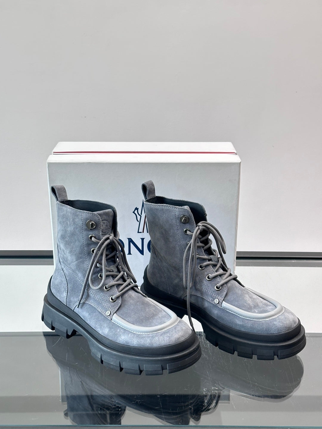 Moncler lace-up boots set on display box; dark blue suede, lace-up front, lug sole