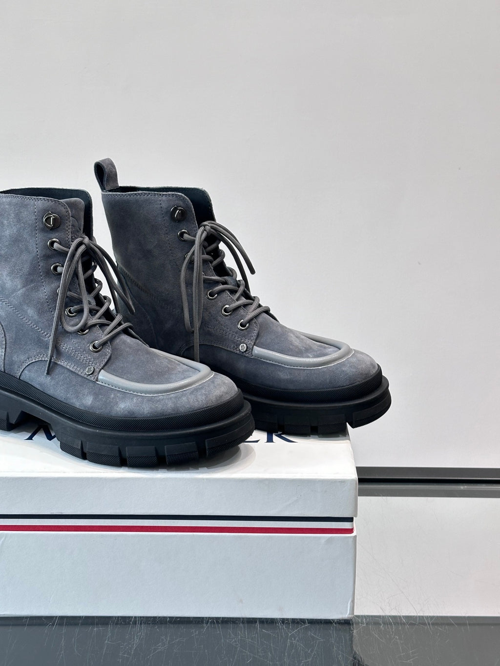 Moncler lace-up ankle boots close angle; dark blue suede, gray laces, chunky lug sole