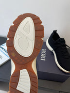 Sneaker outsole view with white tread and Dior logo on gum rubber
