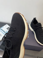 Black knit sneaker side profile with lace-up vamp and gum outsole