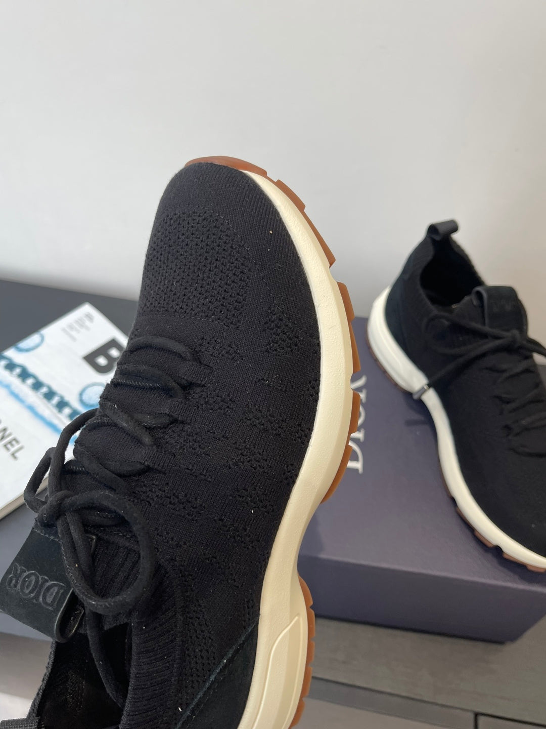 Black knit sneaker side profile with lace-up vamp and gum outsole