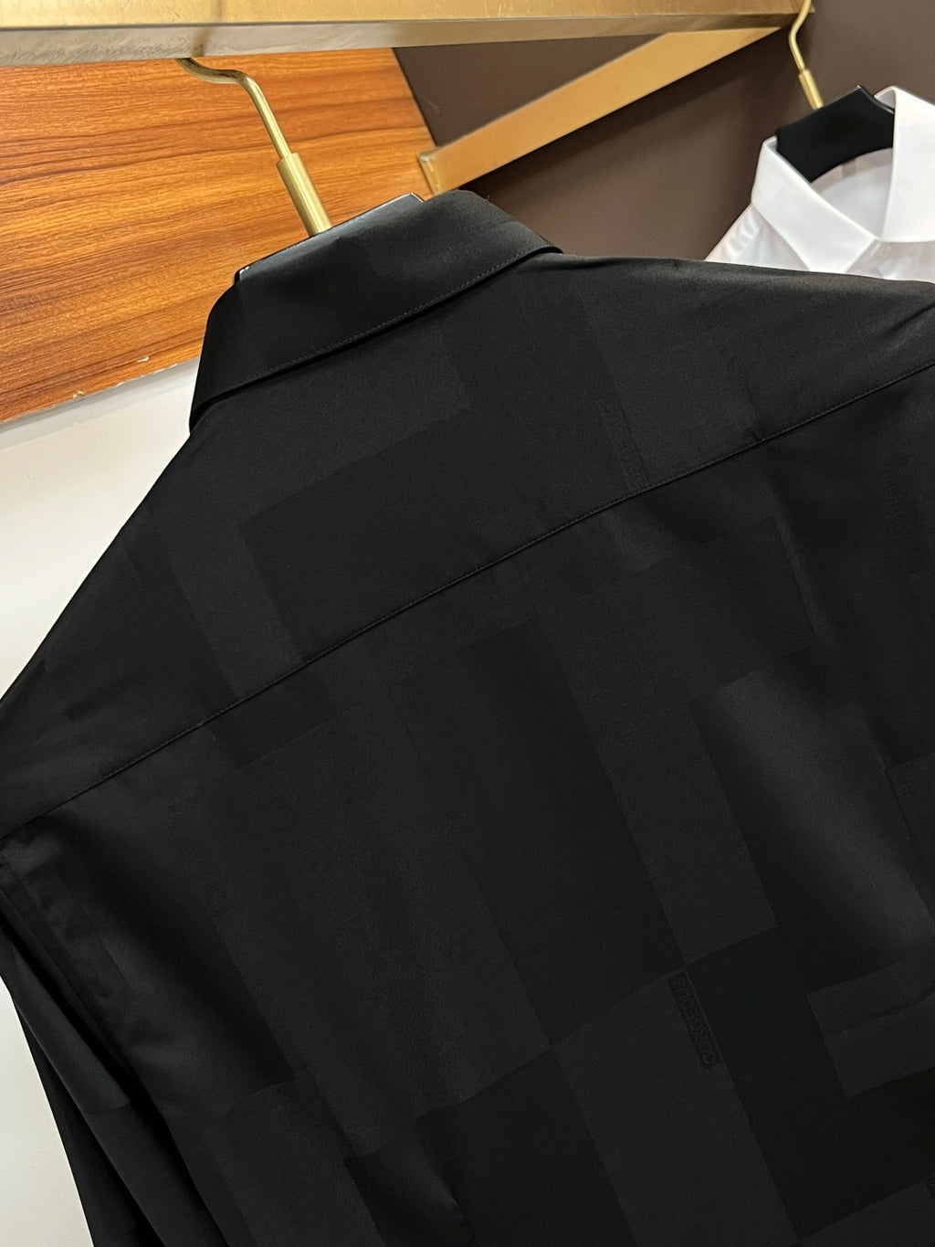 Long-sleeve button-up shirt in dark black, upper back with shoulder yoke seam