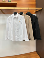 Long-sleeve button-up shirts on hangers in white, beige, and dark black