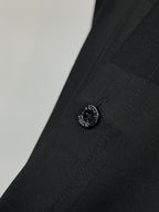 Dark black shirt cuff with round button and stitched detail